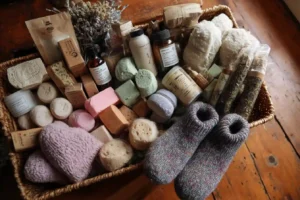 A cozy flat lay of self care basket ideas with bath bombs, candles, skincare products, and herbal tea